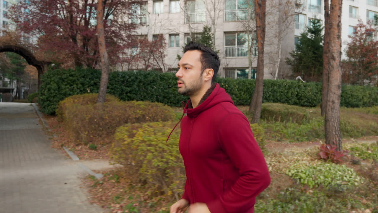 Giovane uomo europeo che corre e si allena all'aperto in un parco cittadino
