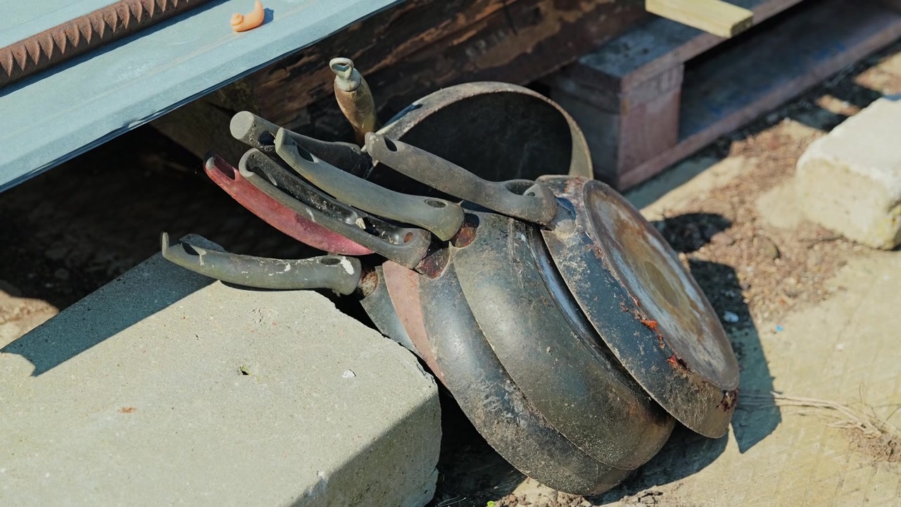 Aged iron cauldrons and utensils reveal heritage craftsmanship outdoors