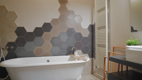 baldosas hexagonales grises y parquet marrón claro en un diseño moderno, con un toque diferente: una clásica bañera tradicional blanca para darle un toque de estilo italiano atemporal.