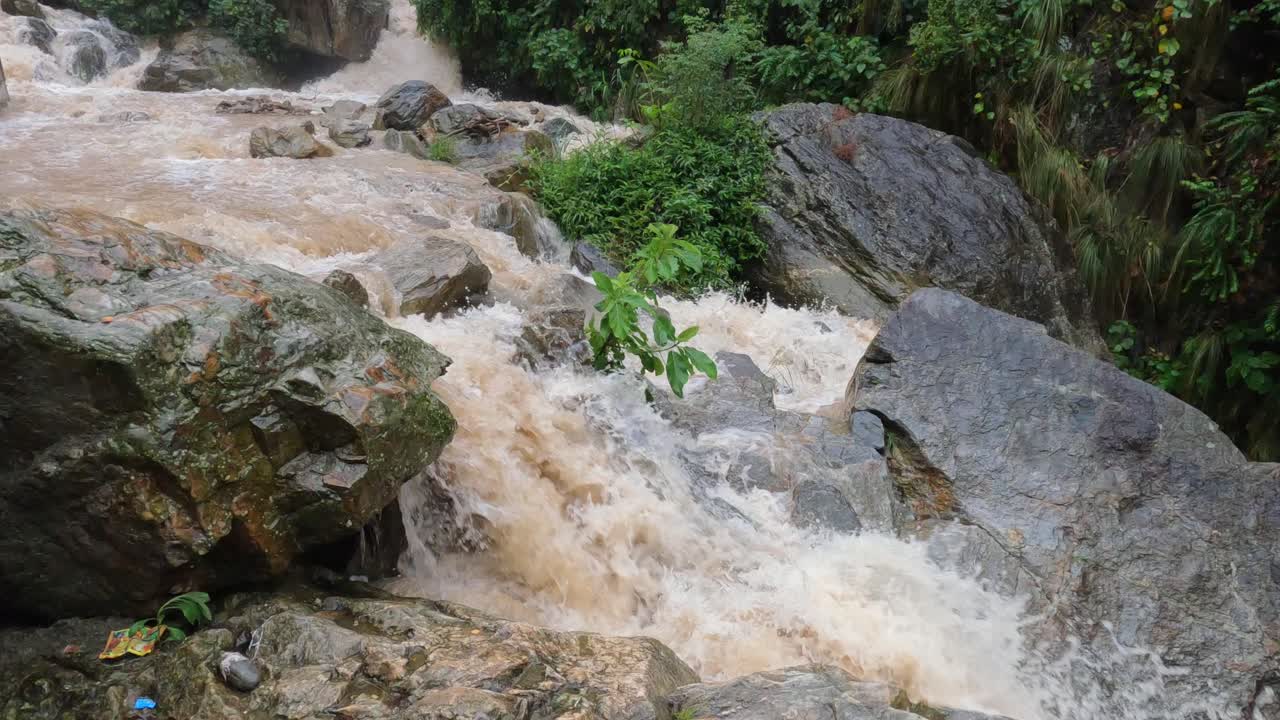 agua que se precipita sobre las rocas de una cascada en las colinas de nepal durante la lluvia de un tifón
