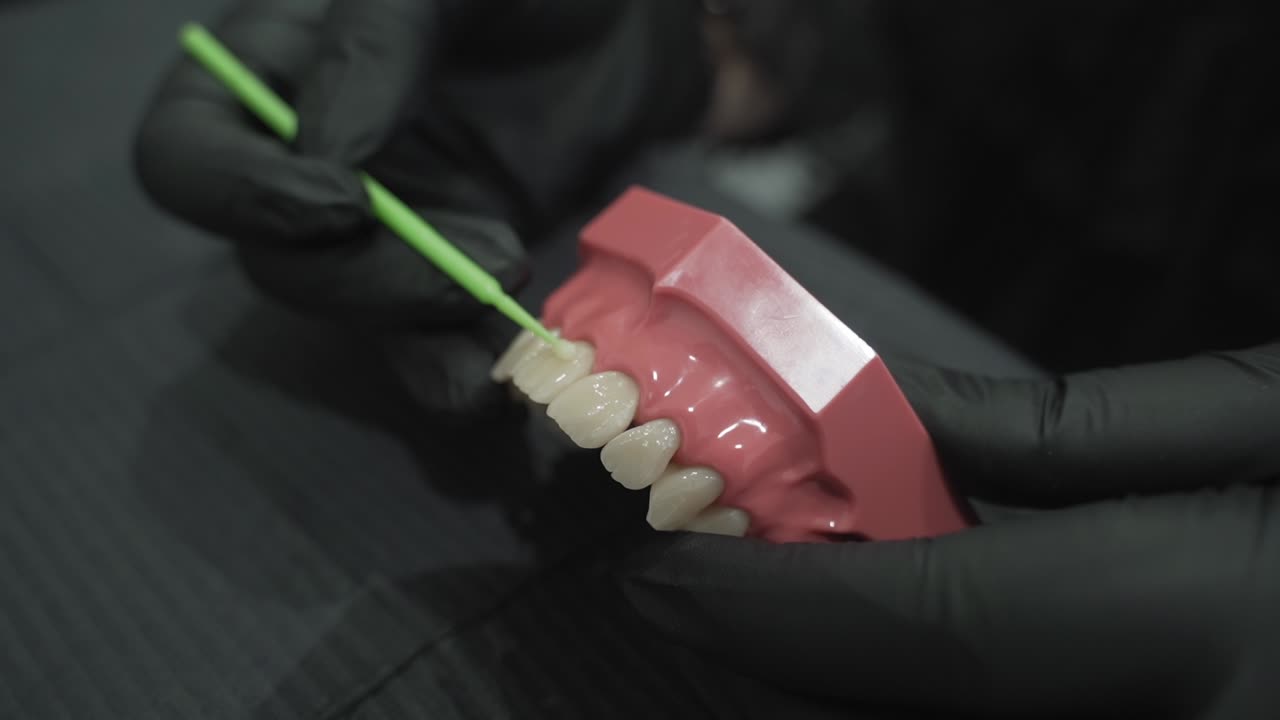 el dentista demuestra la técnica de usar hilo dental en dientes modelo, haciendo hincapié en la precisión del cuidado dental