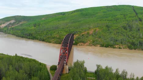 4K-Drone-Video-of-Mears-Memorial-Steel-Truss-Train-Bridge-over-the-Tanana-River-at-Nenana,-Alaska-during-Summer-Day