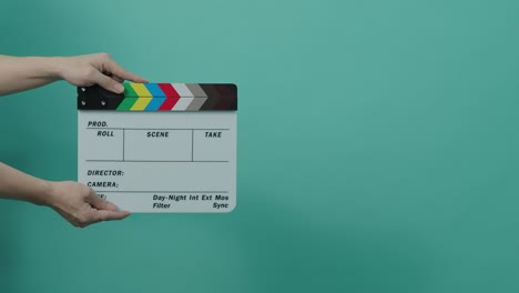 clapperboard hitting. movie film slate. close up hand clapping empty film slate on blue or green screen color background. in and out film slate cutting for video production. film or movie shooting.