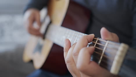enfoque de rack cerca del hombre tocando una guitarra acústica