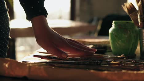 close up footage of accurately manicured female hand choosing brush from a row on the table.