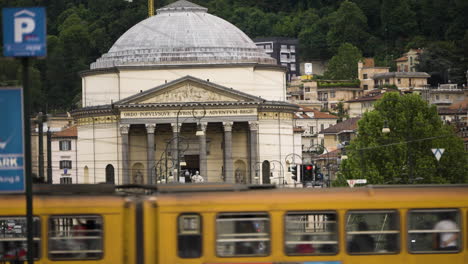 Statische-Zeitlupenaufnahme-Des-Turiner-Zentrums-Mit-Vorbeifahrender-Straßenbahn-Und-Historischem-Wahrzeichen