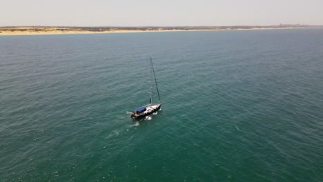 una foto de un dron de un barco navegando frente a la costa en 4k