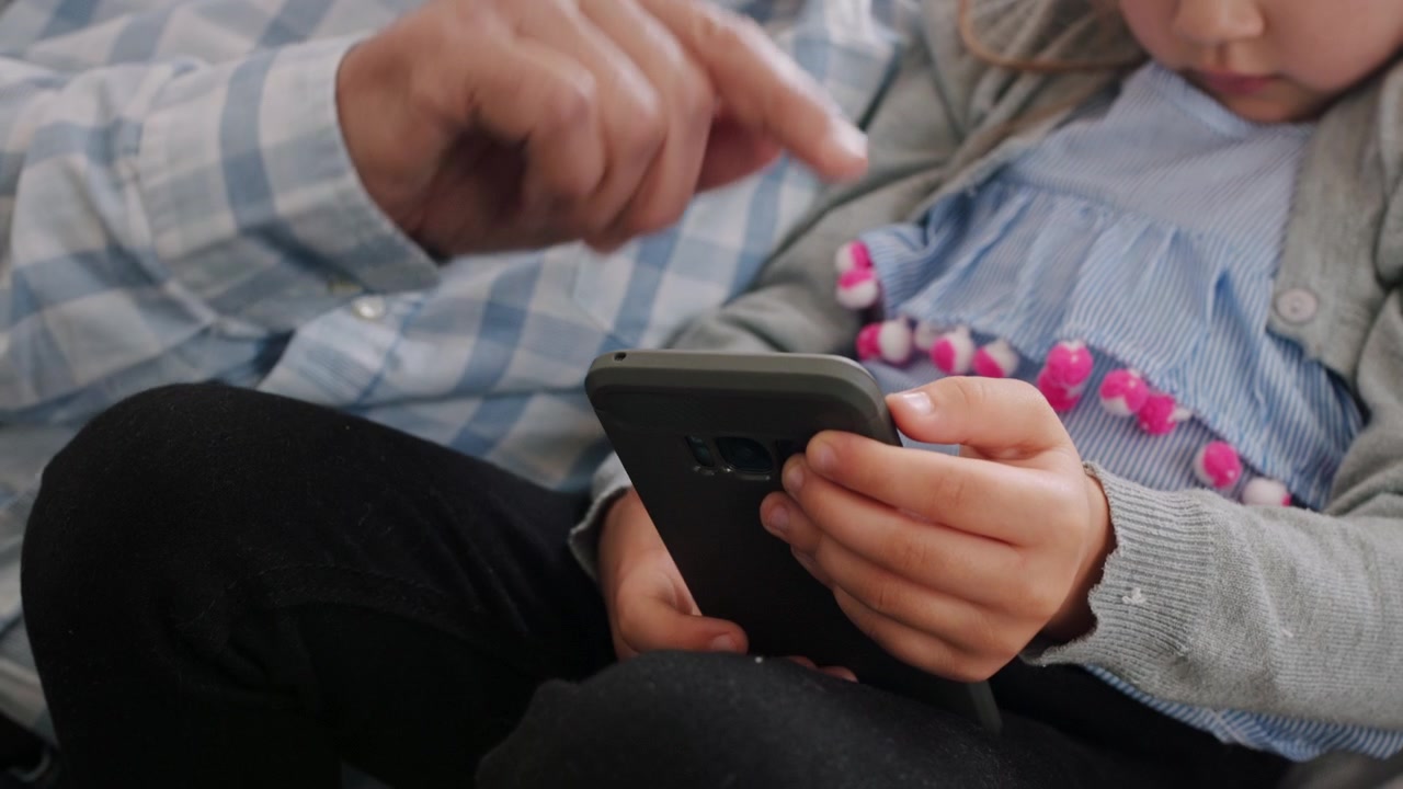 Grandfather and Granddaughter Using Smartphone Together