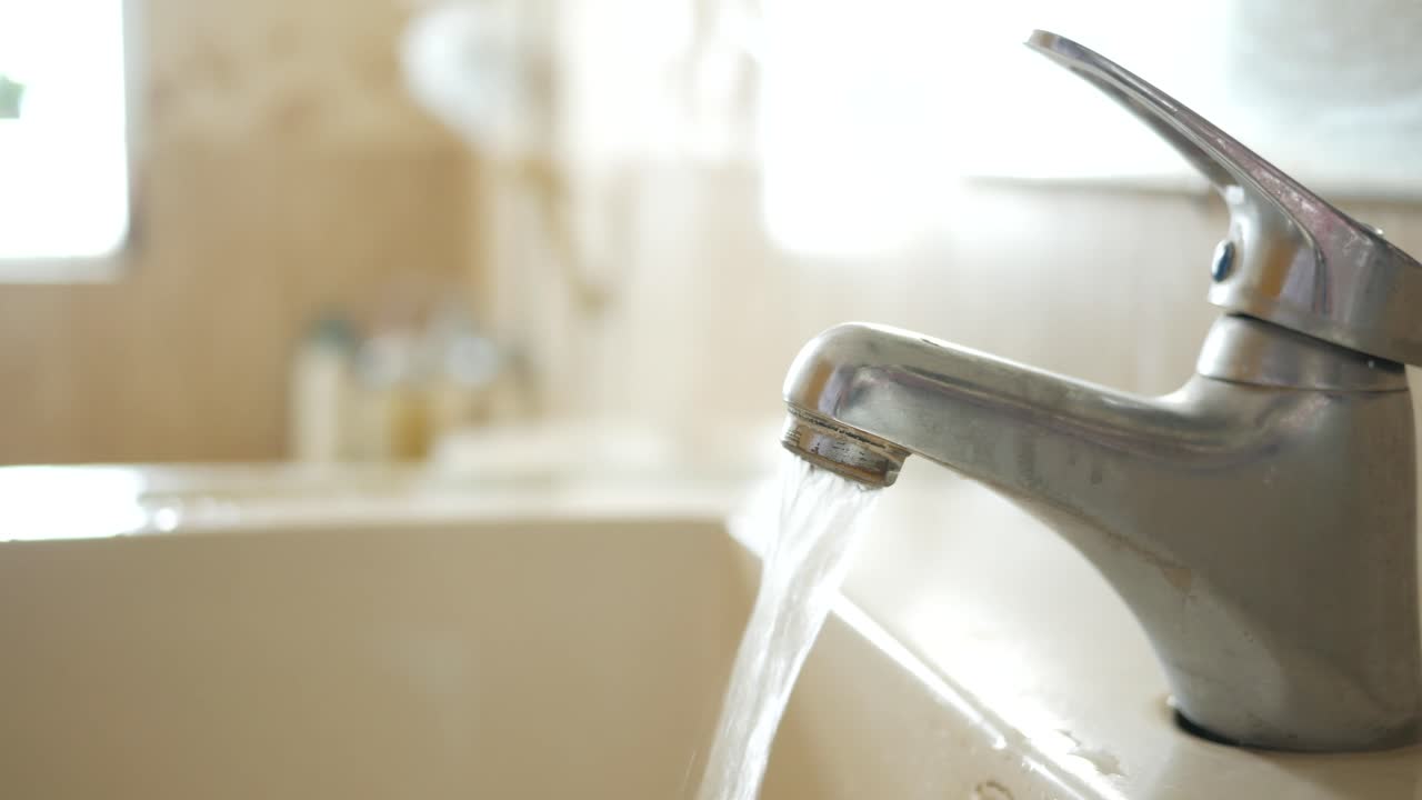 Acqua che scorre da un rubinetto del bagno