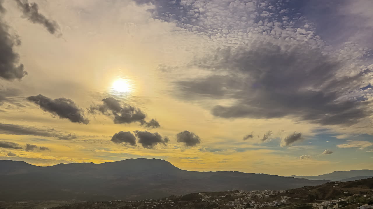 일출과 일몰 동안 산 위의 하늘에 구름 뒤에 햇빛