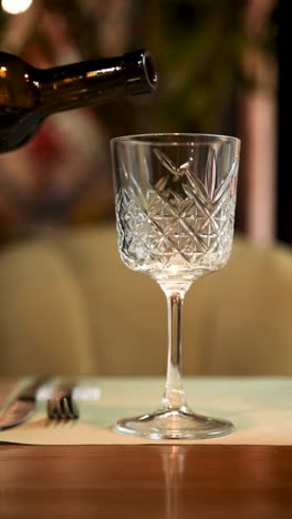 pouring red wine into a glass at a restaurant