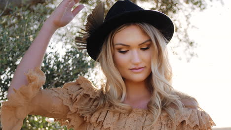 Gracious-cute-Blonde-blue-eyed-woman-dressed-in-Boho-style-posing-under-olive-tree---close-up