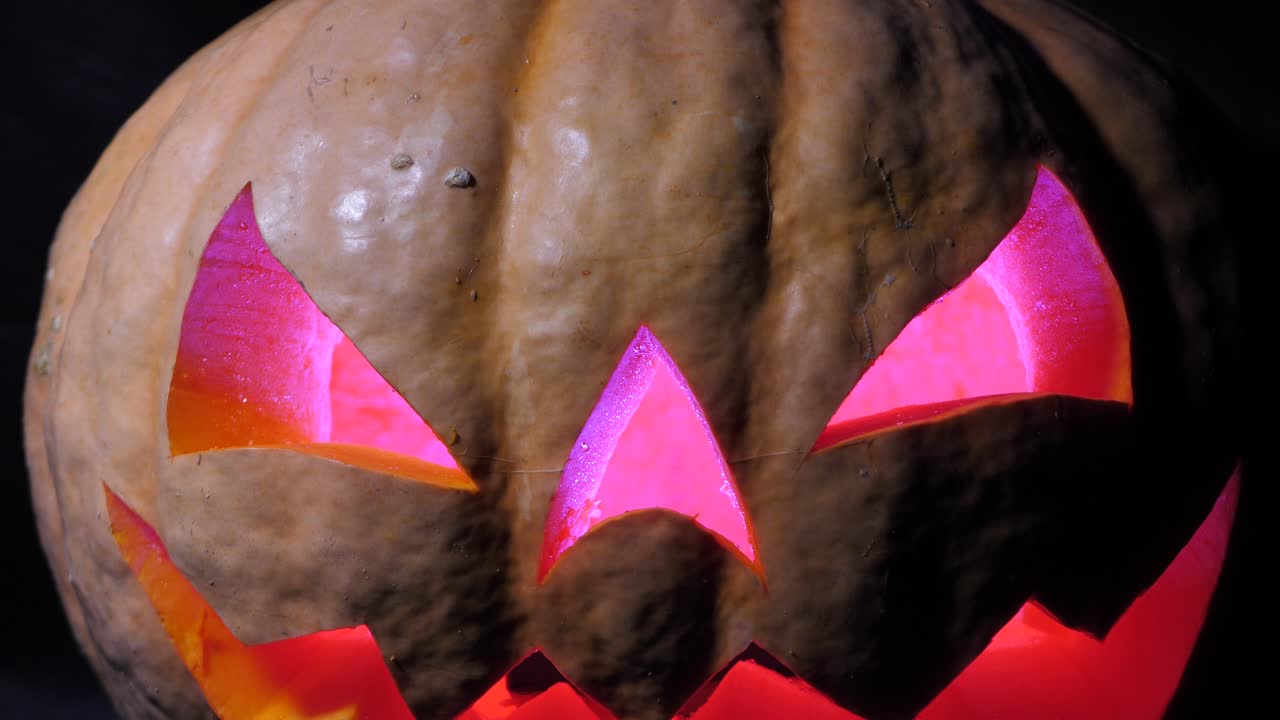 무서운 얼굴과 눈에 거미가 있는 할로윈 호박, 내부의 여러 가지 빛깔의 조명, 할로윈을 위한 매우 무서운 호박