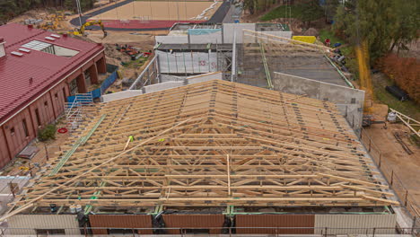 lapso de tiempo diario de la construcción del techo de un edificio escolar y un campo deportivo en una ciudad