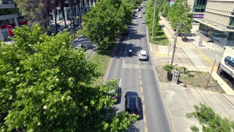 drones aéreos siguen coches modernos en la avenida rápida entre los árboles ciudad latinoamericana