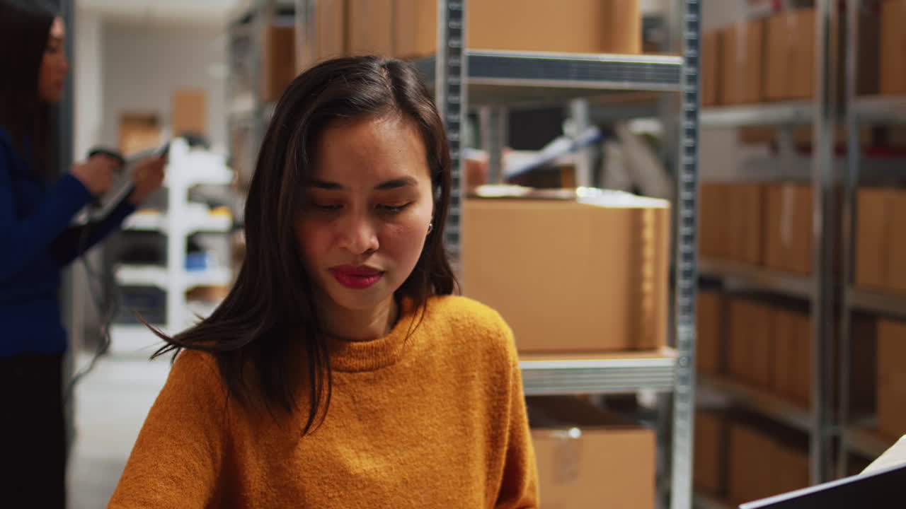 창고에서 노트북으로 일하는 여자