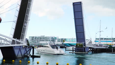 a yacht sailing under the tourist bridge in auckland, new zealand