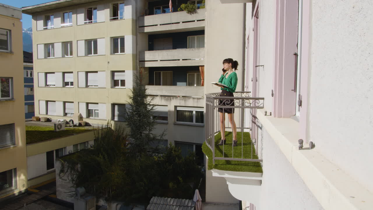 Brunette woman  having a phone call from her balcony