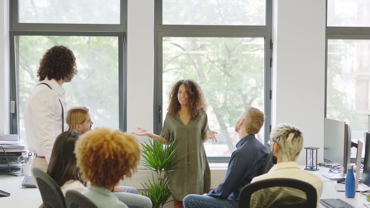 Leder, der præsenterer en idé for medarbejderne i et coworkingmiljø