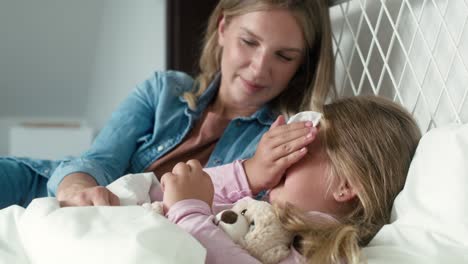 madre cuidando a su hija enferma en casa