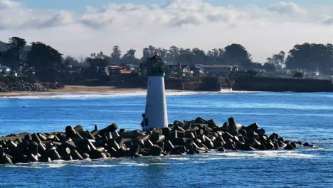 Walton Lighthouse Santa Cruz California USA aerial drone scenic landscape deep blue Monterey Bay Pacific Ocean seagull pelican birds marina harbor jetty morning blue sky mist fog static motion