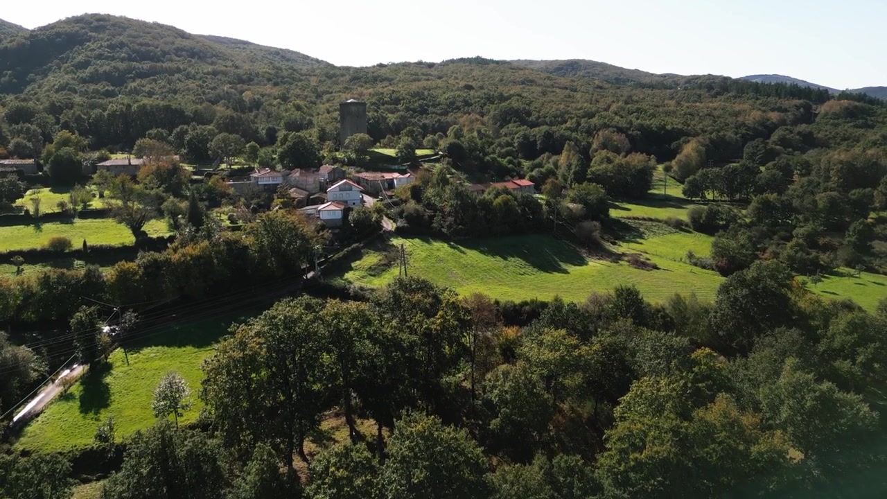 Tornet A Forxa ovanför en lantlig by och skogsmark i Porqueira, Ourense, Galicien, Spanien, flygöversikt
