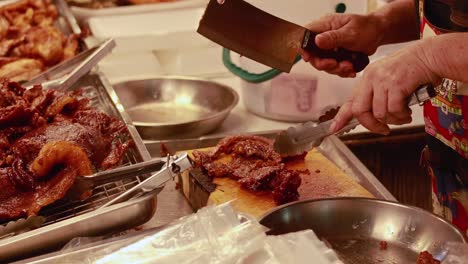 butcher preparing meat at bangkok market stall