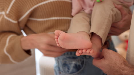 mom, dad and baby, playing with toes at home