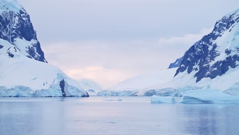 Montañas-Antárticas-Y-Paisajes-Glaciares-Al-Atardecer,-Paso-Del-Canal-Lemaire-Paisaje-Marino-De-Mar-Y-Hielo-En-Una-Escena-Helada-De-Invierno-En-La-Hermosa-Y-Tranquila-Costa-De-La-Península-Antártica