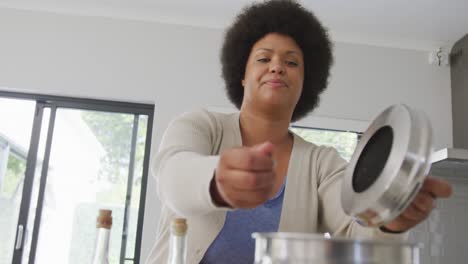 Video-of-happy-plus-size-african-american-woman-preparing-meal