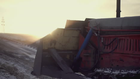 tractor en un campo nevado al atardecer