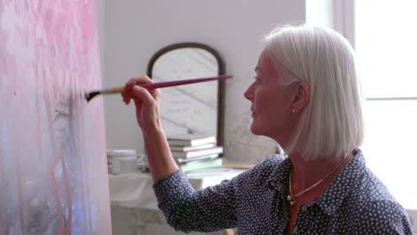 female artist working on painting in studio shot on r3d