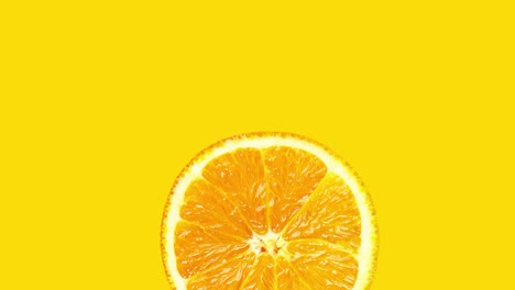 animación de imágenes de una rodaje giratorio de una rebanada de naranja madura y jugosa sobre un fondo amarillo. vitaminas dieta saludable y equilibrada