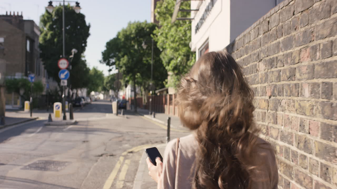 도시를 걸어다니는 스마트 폰 기술 앱을 사용하는 아름다운 여성