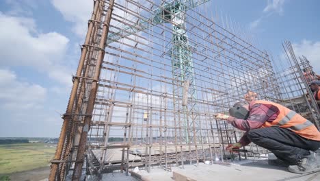 construction worker welding metal rebar for the pouring of monolithic structure