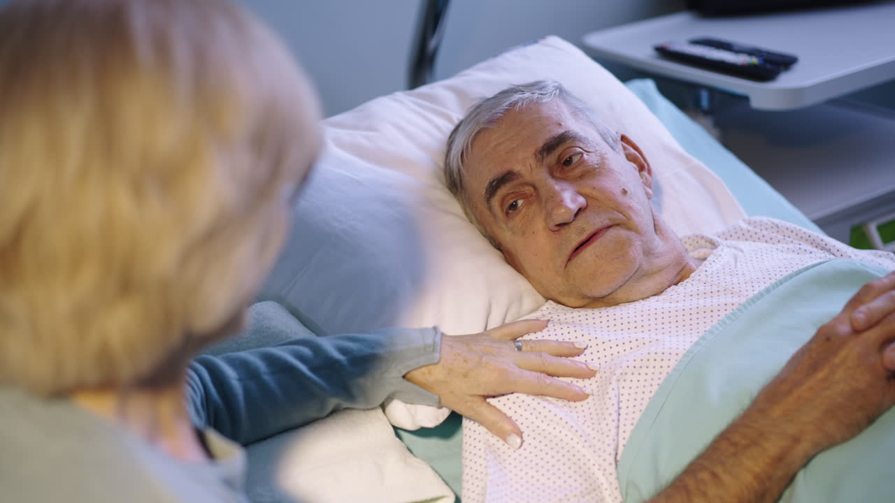 Elderly Man in Hospital Bed Receiving Support