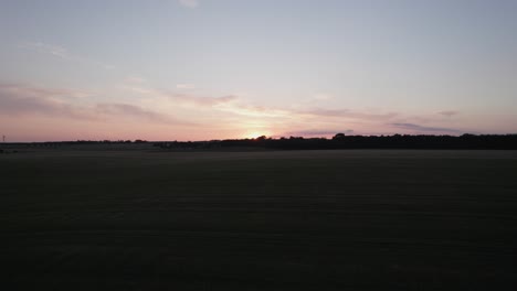 Drone-Shot-of-the-Sunset-over-a-Field-in-Denmark-Scandinavia---Dolly-Shot