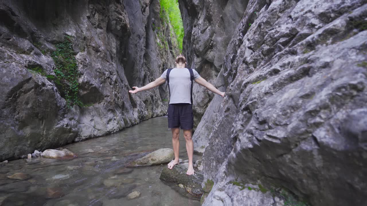 자유롭고 평화로운 젊은이가 협곡의 하천에 있습니다.