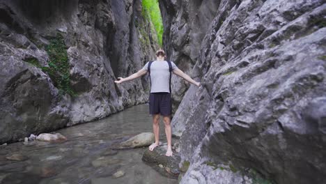 un joven libre y pacífico en el arroyo en el cañón.