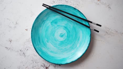 Turquoise-hand-painted-ceramic-serving-plate-with-wooden-chopsticks-on-side