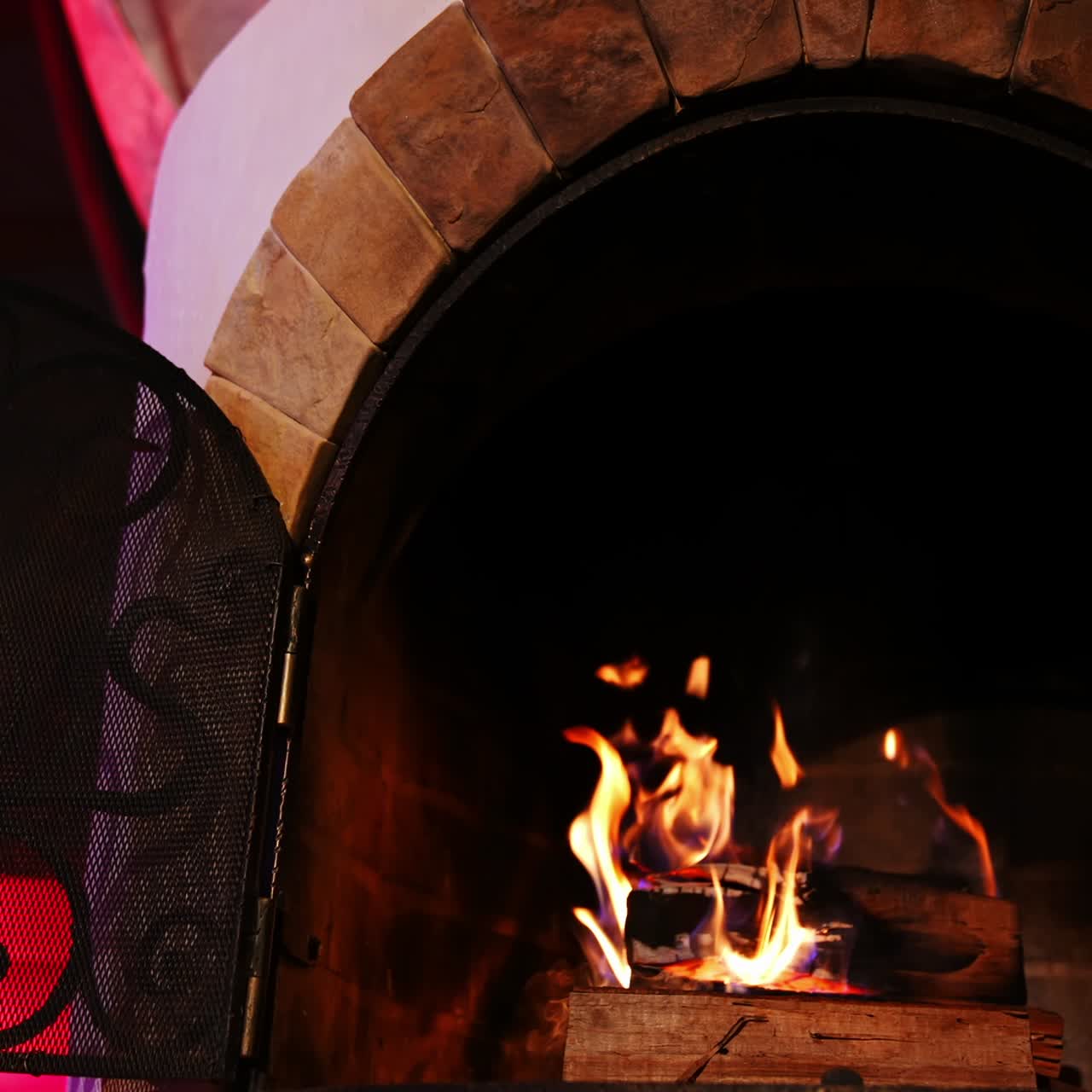 Wooden logs burning in modern fireplace. Beautiful stone fireplace at home. Romantic fireplace makes a cosy atmosphere