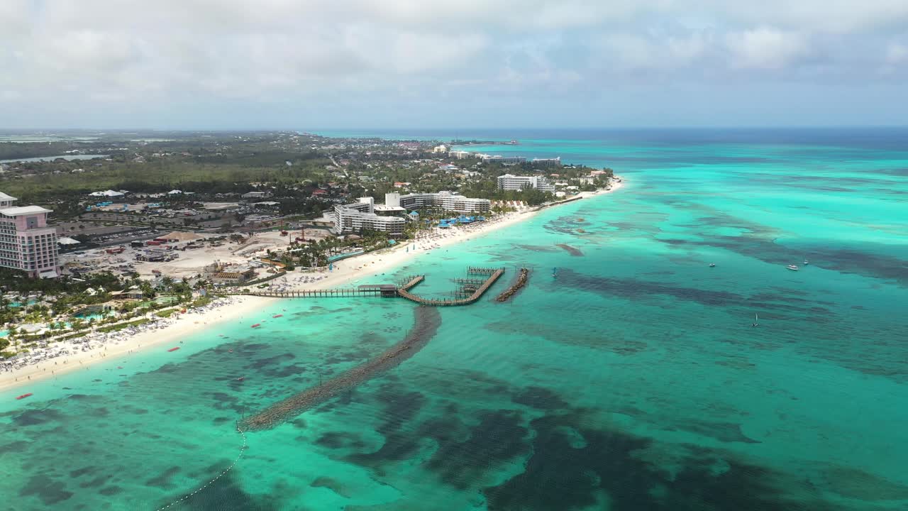 Vibrant Nassau Beachfront, Bahamas, Drone Aerial View of Pier, White Sand Beach and Luxury Resorts