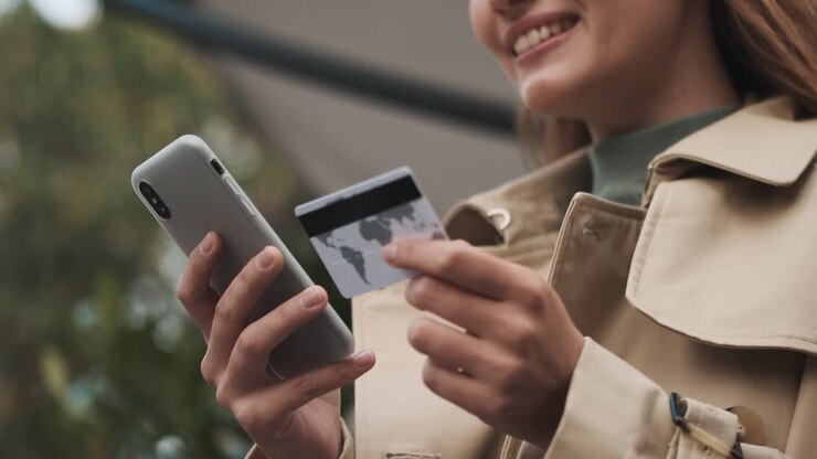 Caucasian female student online shopping on smartphone outdoors.