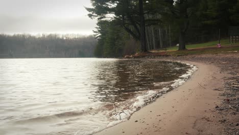 Sanftes-Wasser-Plätschert-Am-öffentlichen-Strand-Auf-Das-Sandige-Ufer