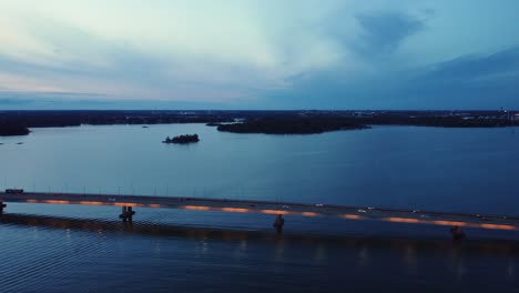 Evening-vehicle-traffic-crosses-illuminated-bridge-at-dusk-blue-hour