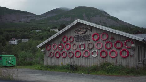 fachada de un edificio con botas salvavidas en el pueblo pesquero de torsken en senja, noruega