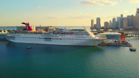 Karnevalskreuzfahrtschiff-Im-Hafen-Von-Miami,-Blaues-Wasser,-Skyline-Der-Innenstadt-Von-Miami,-Blaues-Wasser,-Sonnenuntergang,-Paradiesurlaub-Menschen,-Die-Nach-Bahamas-Reisen