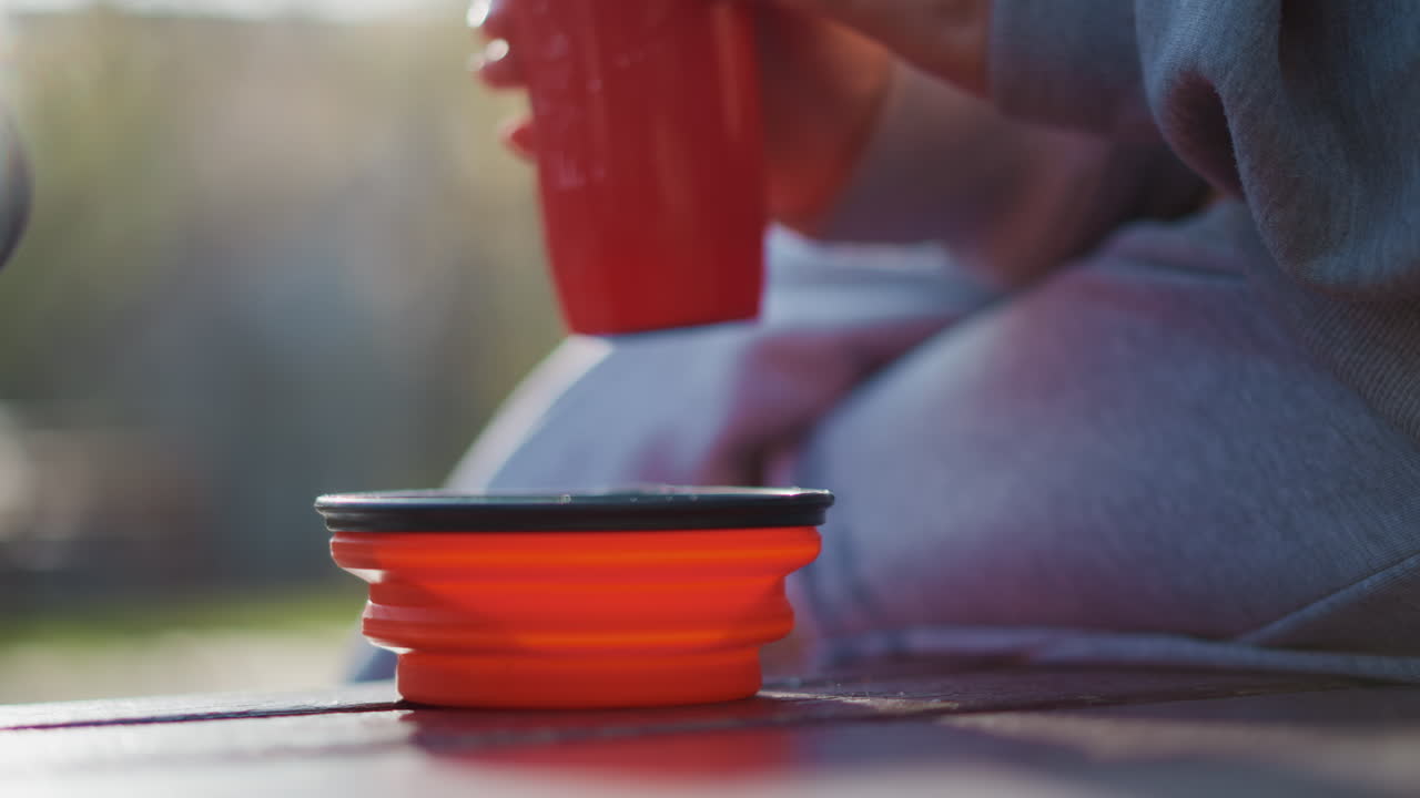 섬세한 반려동물 액세서리 장면, 흐르는 물과 함께 조리대 위에 놓인 접이식 식기, 조용한 배경 디테일 속에서 부드러운 물줄기를 받는 콤팩트한 반려동물 용기를 섬세하게 묘사