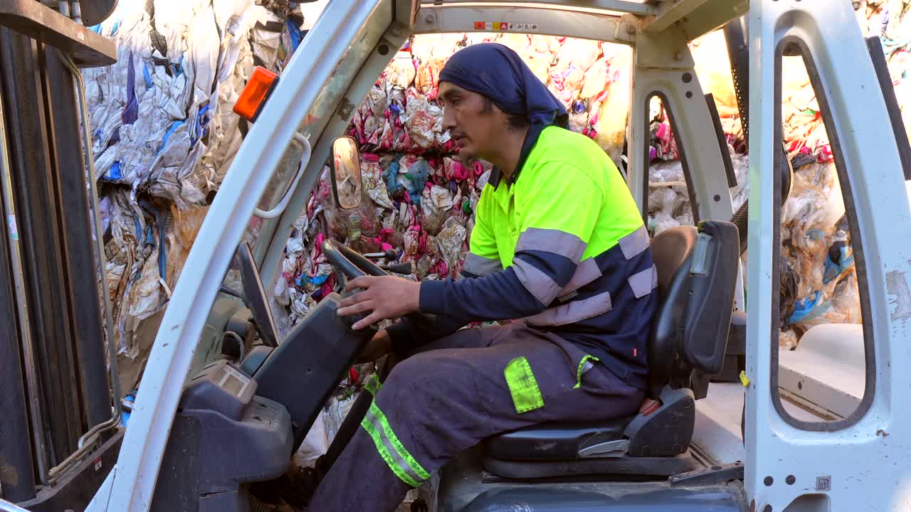 Forklift operator working in a plastic recycling facility