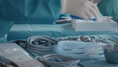 manos con guantes, asistente médico preparando herramientas para la operación